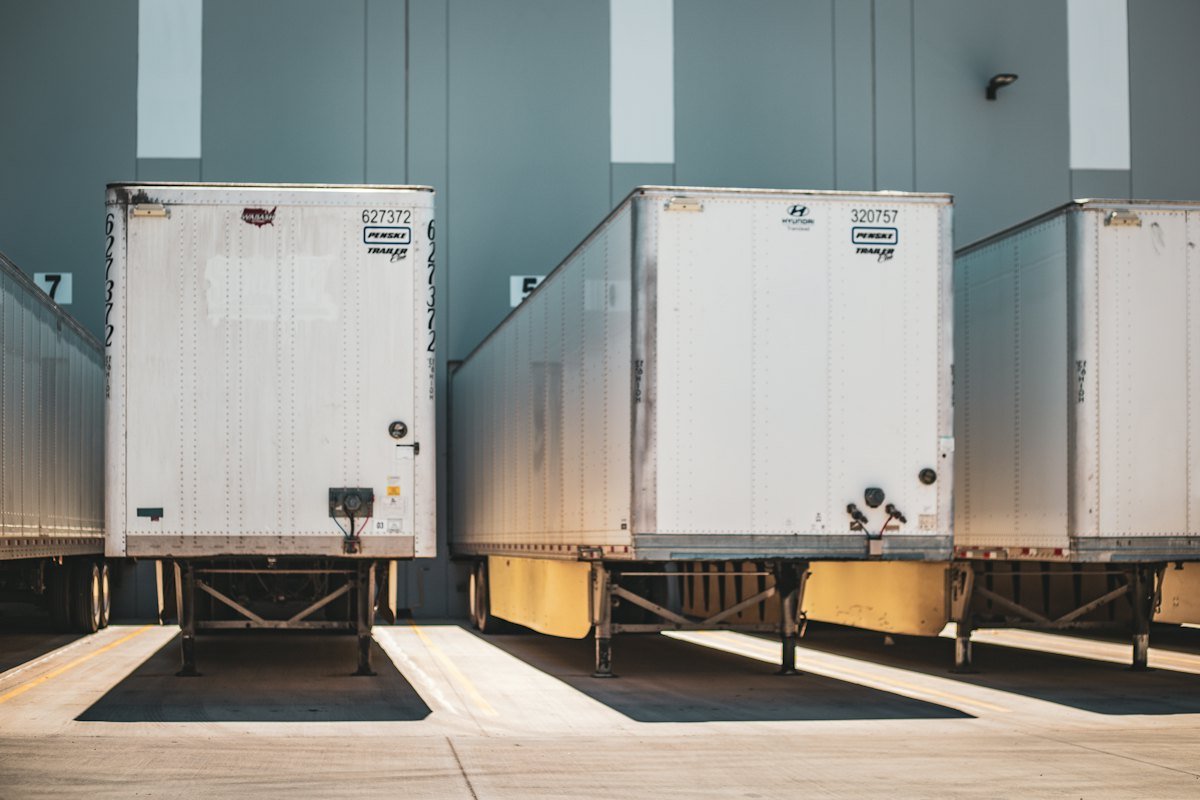 Row of enclosed semi trailers parked at a lot